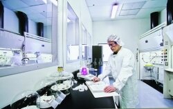 This is a photo of a Strem Chemicals employee handling synthesis as well as validation and stability study in a kilo-scale clean room.