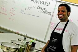Sorell Massenburg, a teaching fellow, stands in front of a whiteboard, preparing to carry out cooking experiments in Harvard’s food-safe laboratory.