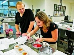 Harvard lab director Héloïse Vilaseca (right) demonstrates spherification, a culinary technique in which a liquid mix is given a thin solid shell, while teaching fellow Jesse Amato-Grill (left) looks on.