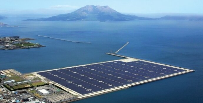 A giant solar panel floats at the end of a peninsula. A mountain island can be seen in the background near the horizon.